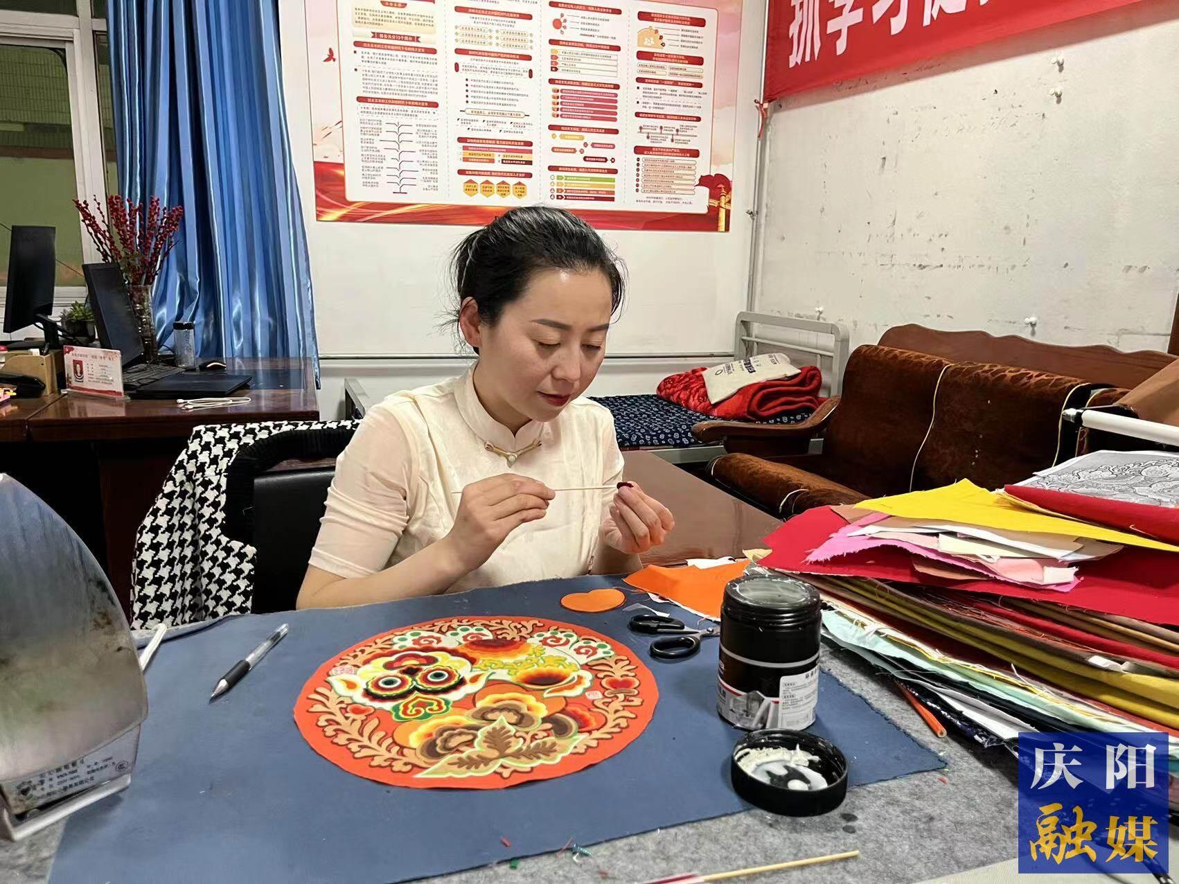 李慶英正在創(chuàng)作布貼畫作品。